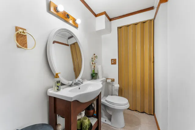 a bathroom with a toilet a sink and a mirror