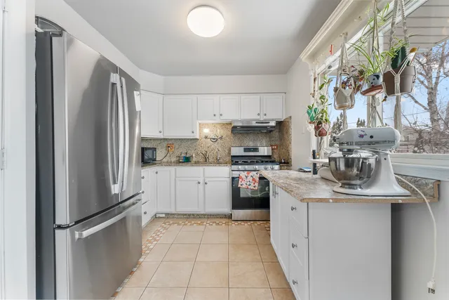 a kitchen with stainless steel appliances granite countertop a refrigerator sink and stove