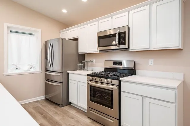 a kitchen with a sink cabinets and wooden floor