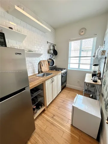 a kitchen with stainless steel appliances a stove a sink cabinets and a window
