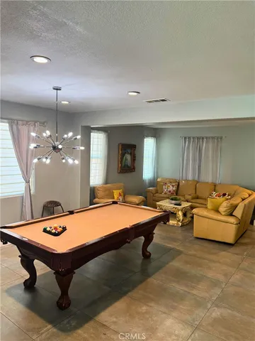 a room with pool table and windows