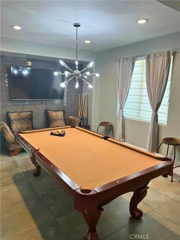 a room with pool table and windows