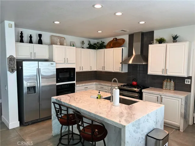 a kitchen with a refrigerator a stove a sink and cabinets
