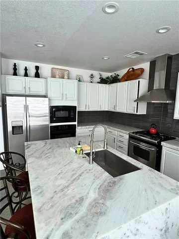 a kitchen with stainless steel appliances kitchen island granite countertop a stove and a sink