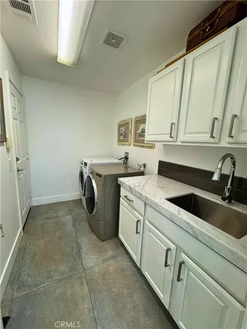 a utility room with sink dryer and washer