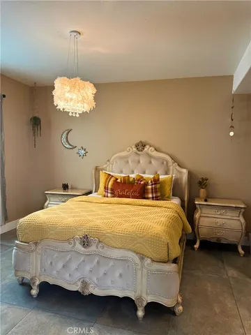 a bedroom with a bed and chandelier