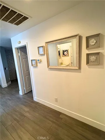 a view of a hallway with wooden floor and closet