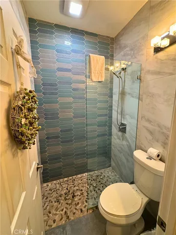 a bathroom with a toilet and a shower