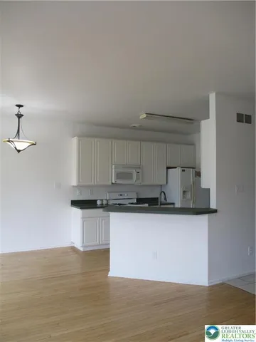 a view of empty room with wooden floor and windows