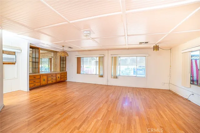 a view of empty room with wooden floor