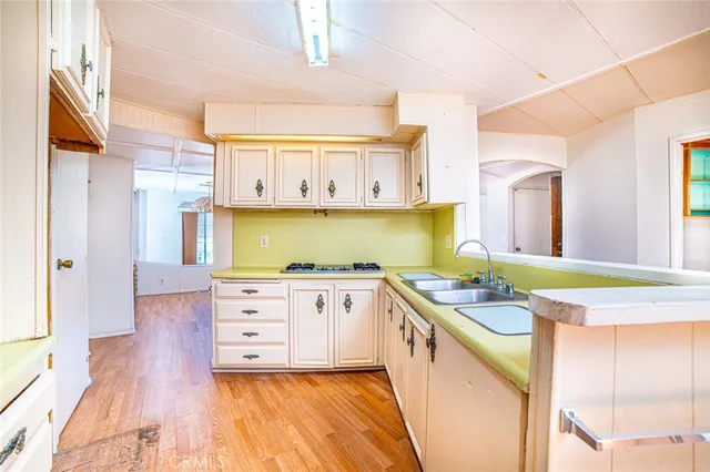 a kitchen with stainless steel appliances cabinets and a wooden floor