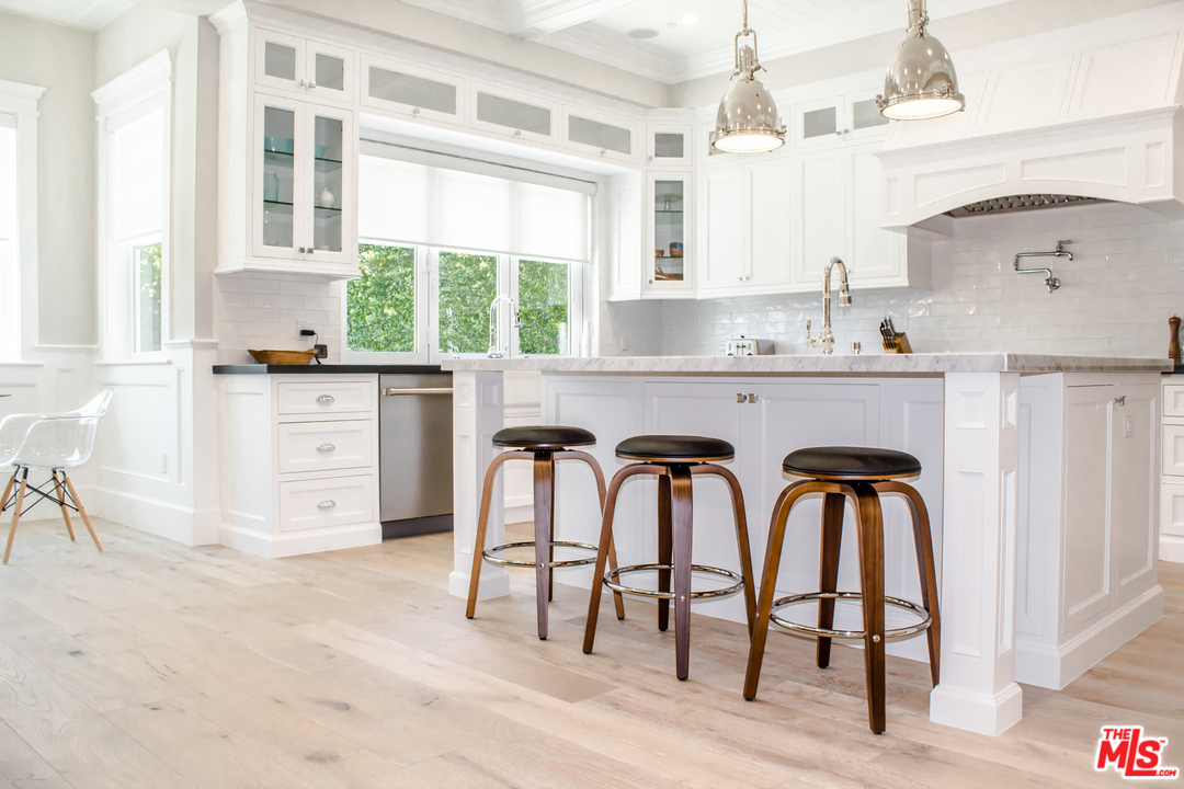 15714 Morrison Street Encino, CA 91436 - Photo 22 of 49 a kitchen with stainless steel appliances granite countertop a table chairs sink and cabinets