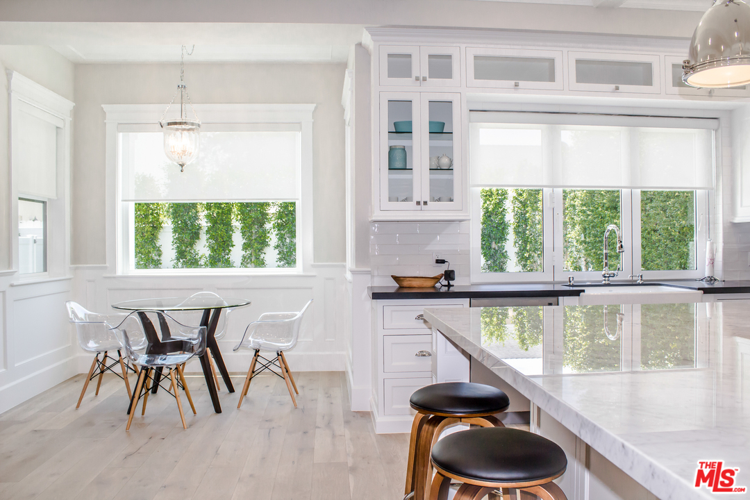 15714 Morrison Street Encino, CA 91436 - Photo 23 of 49 a view of a dining room with furniture a chandelier and wooden floor