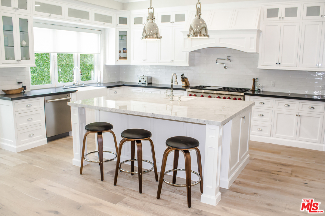 15714 Morrison Street Encino, CA 91436 - Photo 4 of 49 a kitchen with stainless steel appliances granite countertop a table chairs sink and cabinets
