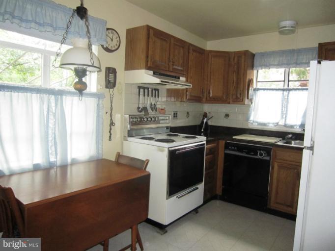 634 Murdock Road Baltimore, MD 21212 - Photo 6 of 23 a kitchen with stainless steel appliances granite countertop a stove a sink dishwasher and cabinets with wooden floor