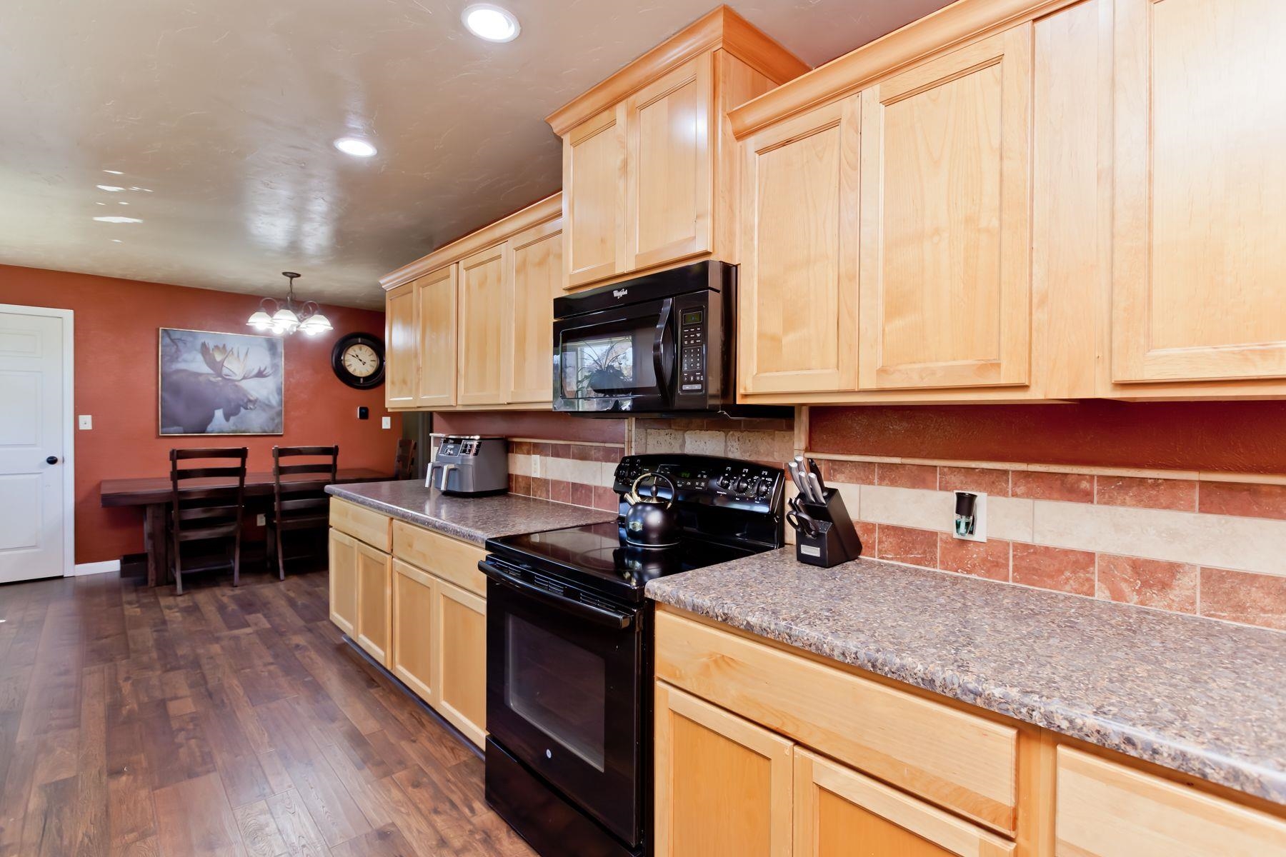498 Sheldon Road Grand Junction, CO 81504 - Photo 13 of 42 a kitchen with granite countertop a stove a sink and a microwave