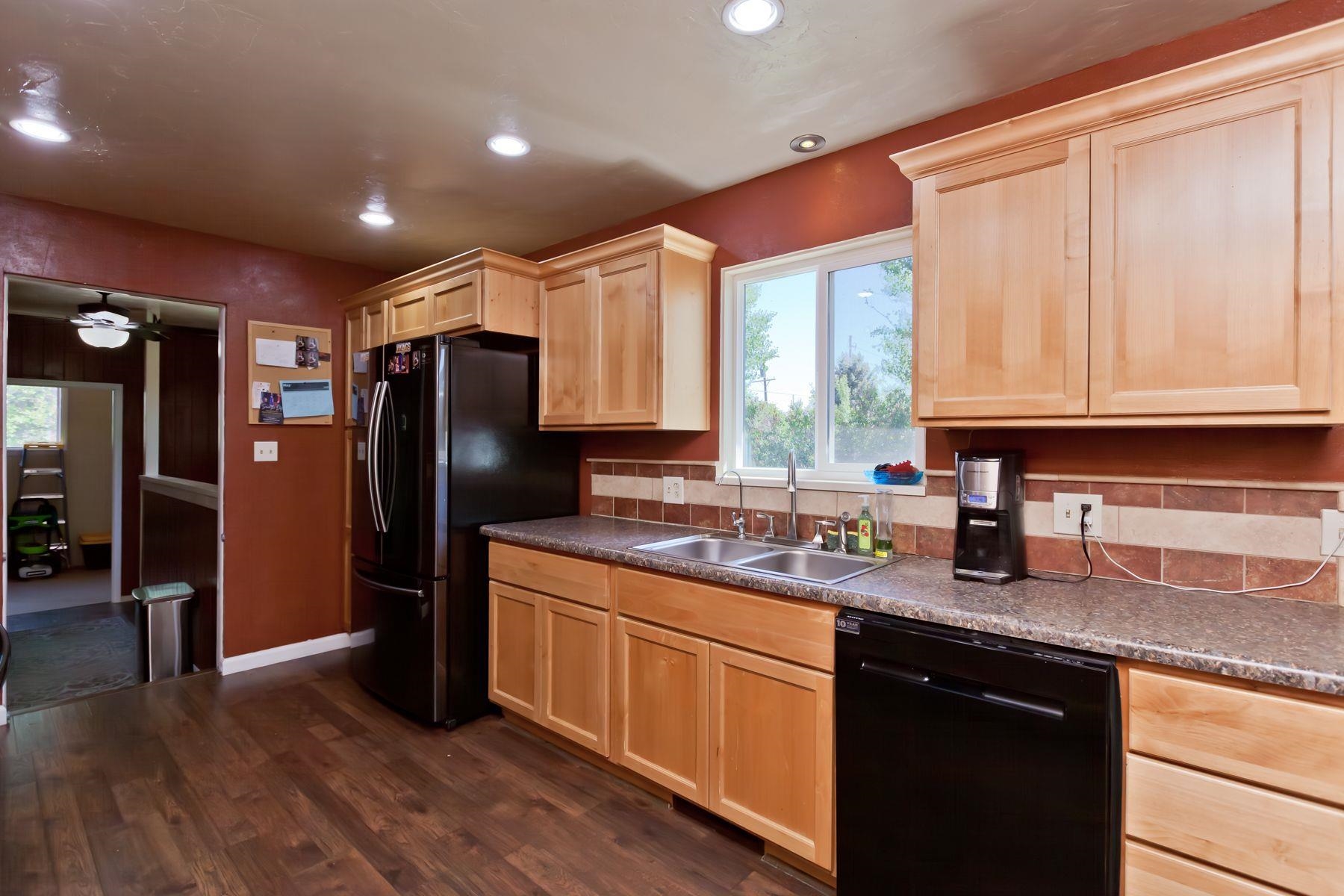 498 Sheldon Road Grand Junction, CO 81504 - Photo 15 of 42 a kitchen with stainless steel appliances granite countertop a refrigerator a sink dishwasher a stove and white countertops with wooden floor