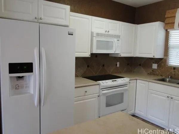 a kitchen with white cabinets and white appliances