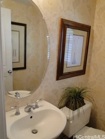 a bathroom with a toilet a sink and mirror