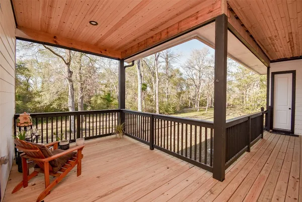 a view of backyard with large trees and wooden fence