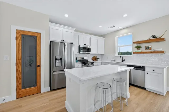 a kitchen with a sink a refrigerator a stove and wooden floor