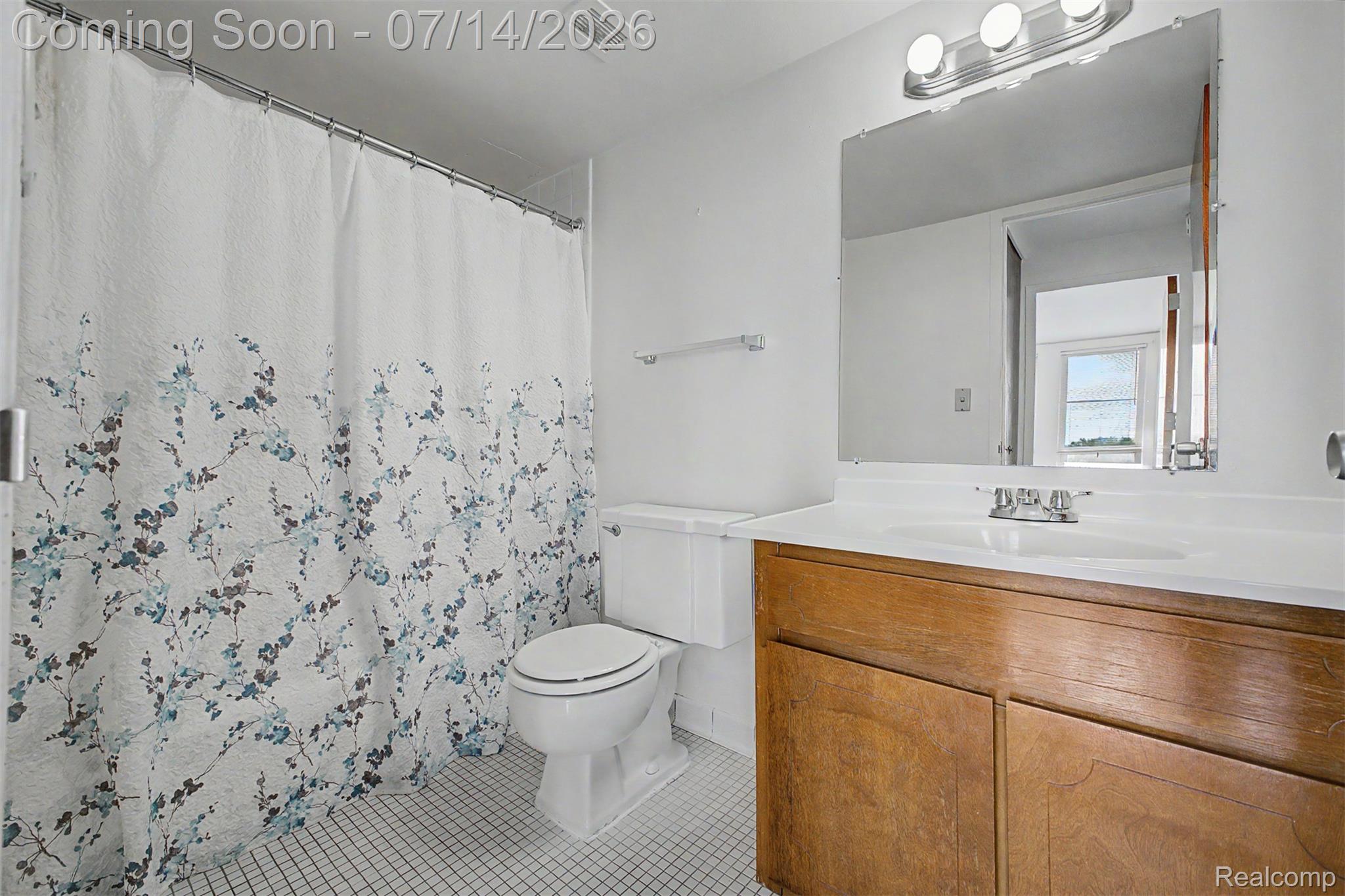 22700 Garrison Street, Unit 707 Dearborn, MI 48124 - Photo 15 of 22 Bathroom featuring a wood-finish vanity with an integrated sink and a large frameless mirror
