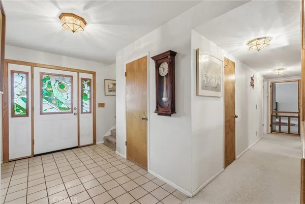 a living room with furniture a flat screen tv and a floor to ceiling window