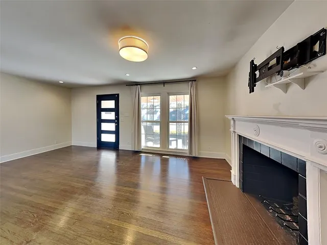 an empty room with windows and fireplace