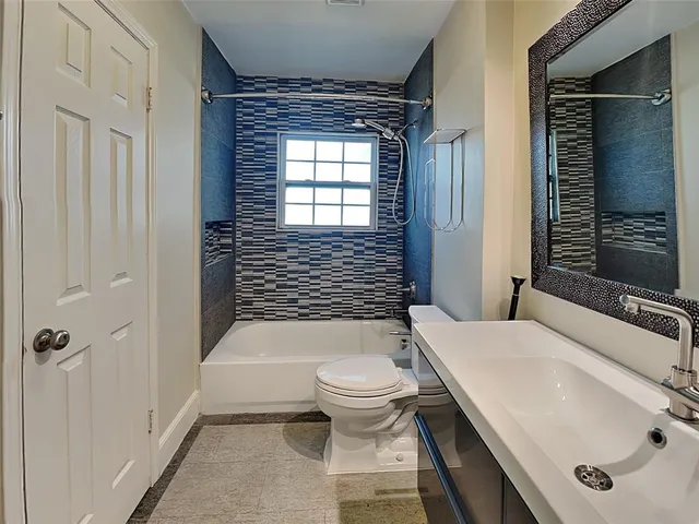a bathroom with a sink a toilet a mirror and shower