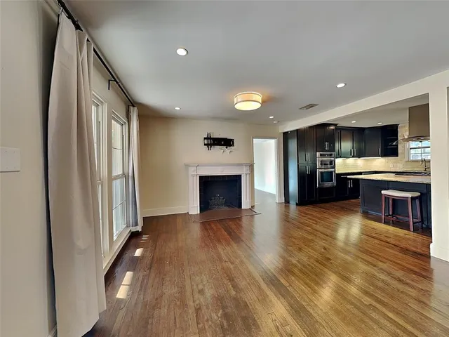 an open kitchen view with wooden floor and a fireplace
