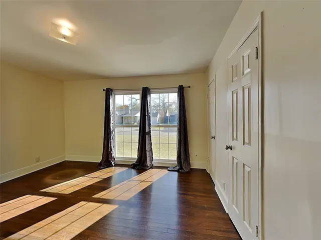 a view of a room with wooden floor and windows