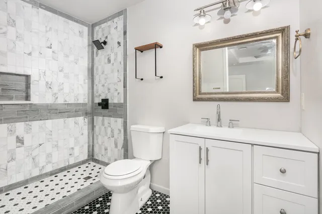 a bathroom with a sink a toilet and shower