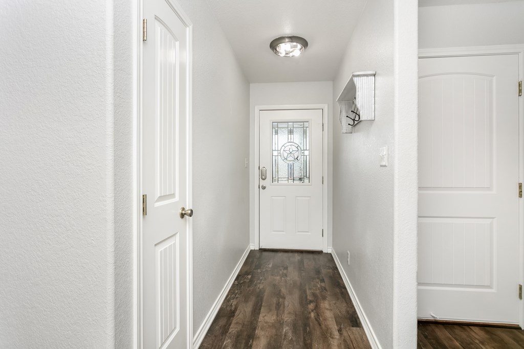 211 Green Oaks Loop Fredericksburg, TX 78624 - Photo 16 of 22 a view of a hallway with wooden floor and a bathroom