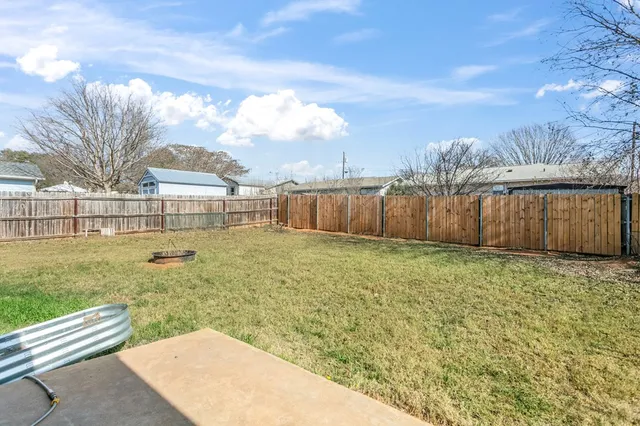 a view of a backyard with wooden fence