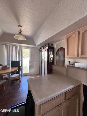 a kitchen with a refrigerator a sink dishwasher a dining table and chairs with wooden floor