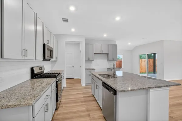 a kitchen with stainless steel appliances granite countertop a sink stove and refrigerator