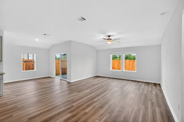 an empty room with window and wooden floor