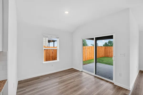 an empty room that has wooden floor and windows
