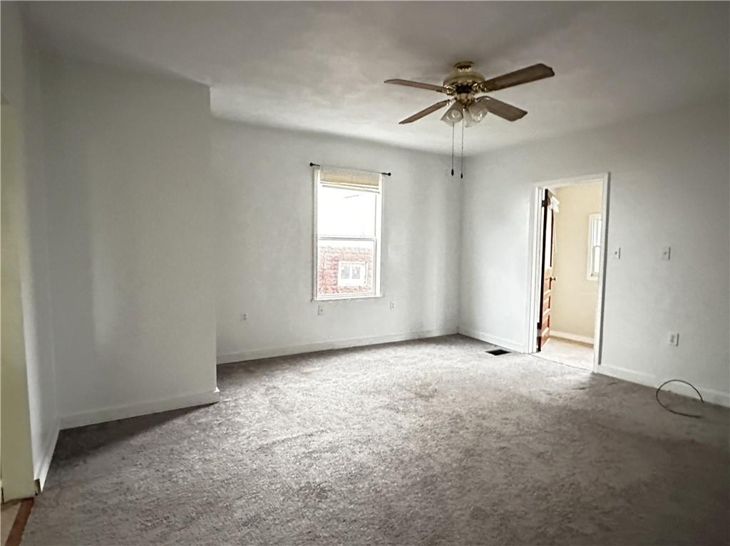 259 High Street Mount Pleasant, PA 15666 - Photo 2 of 19 an empty room with a ceiling fan and window