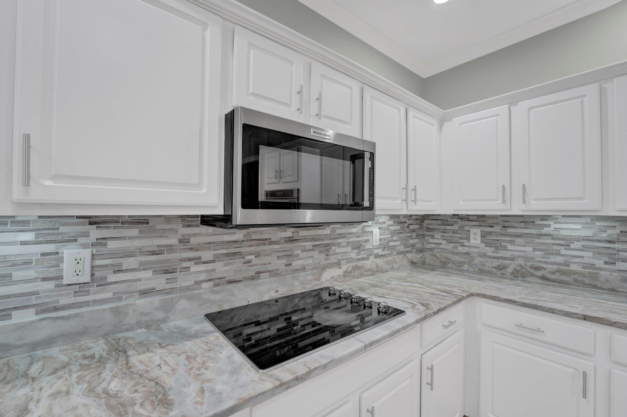 1331 Riding Brook Drive Collierville, TN 38017 - Photo 16 of 39 Kitchen featuring white cabinetry, backsplash, and black electric stovetop