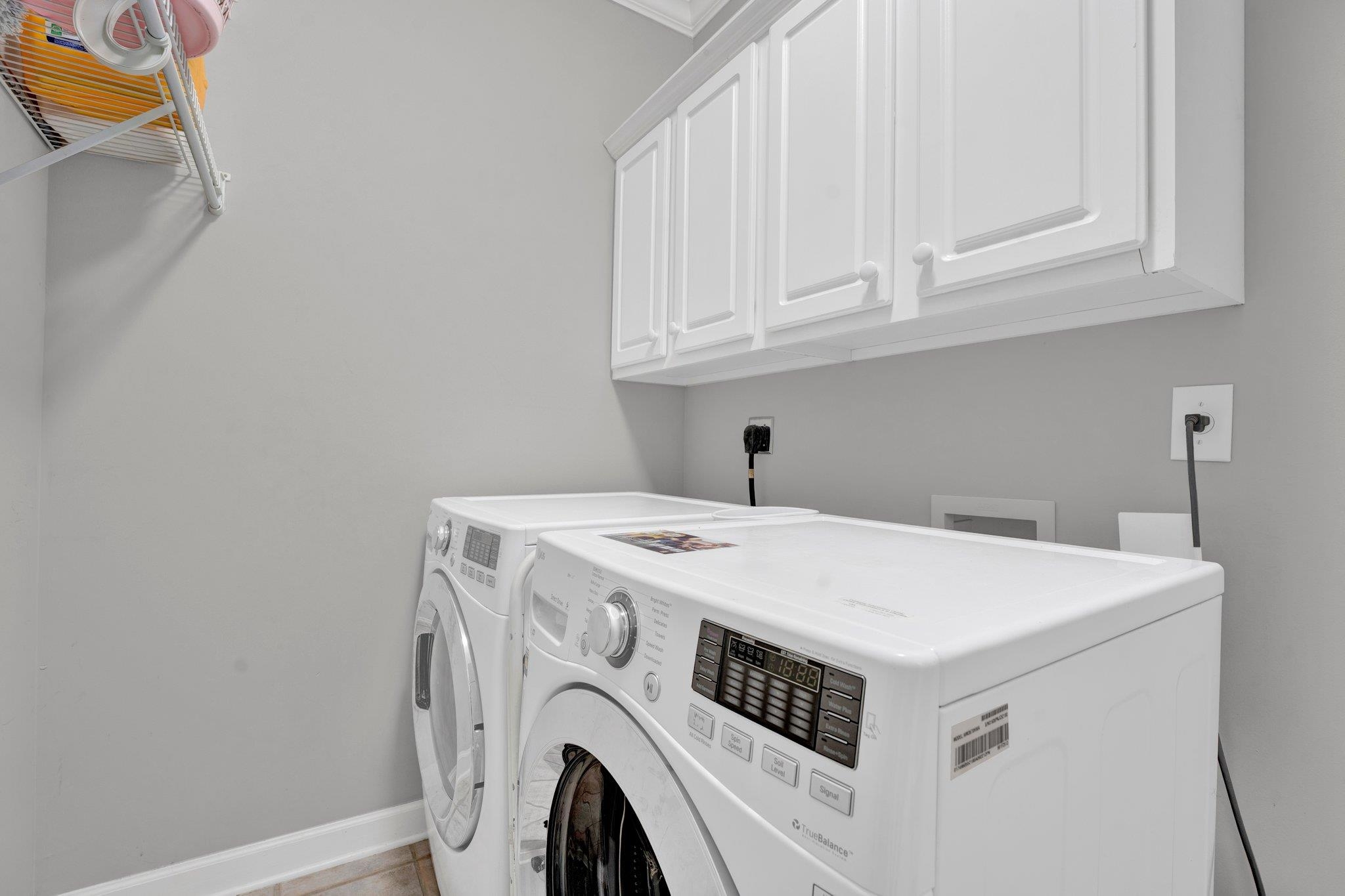1331 Riding Brook Drive Collierville, TN 38017 - Photo 23 of 39 Clothes washing area featuring washing machine and dryer, cabinets, and light tile patterned floors
