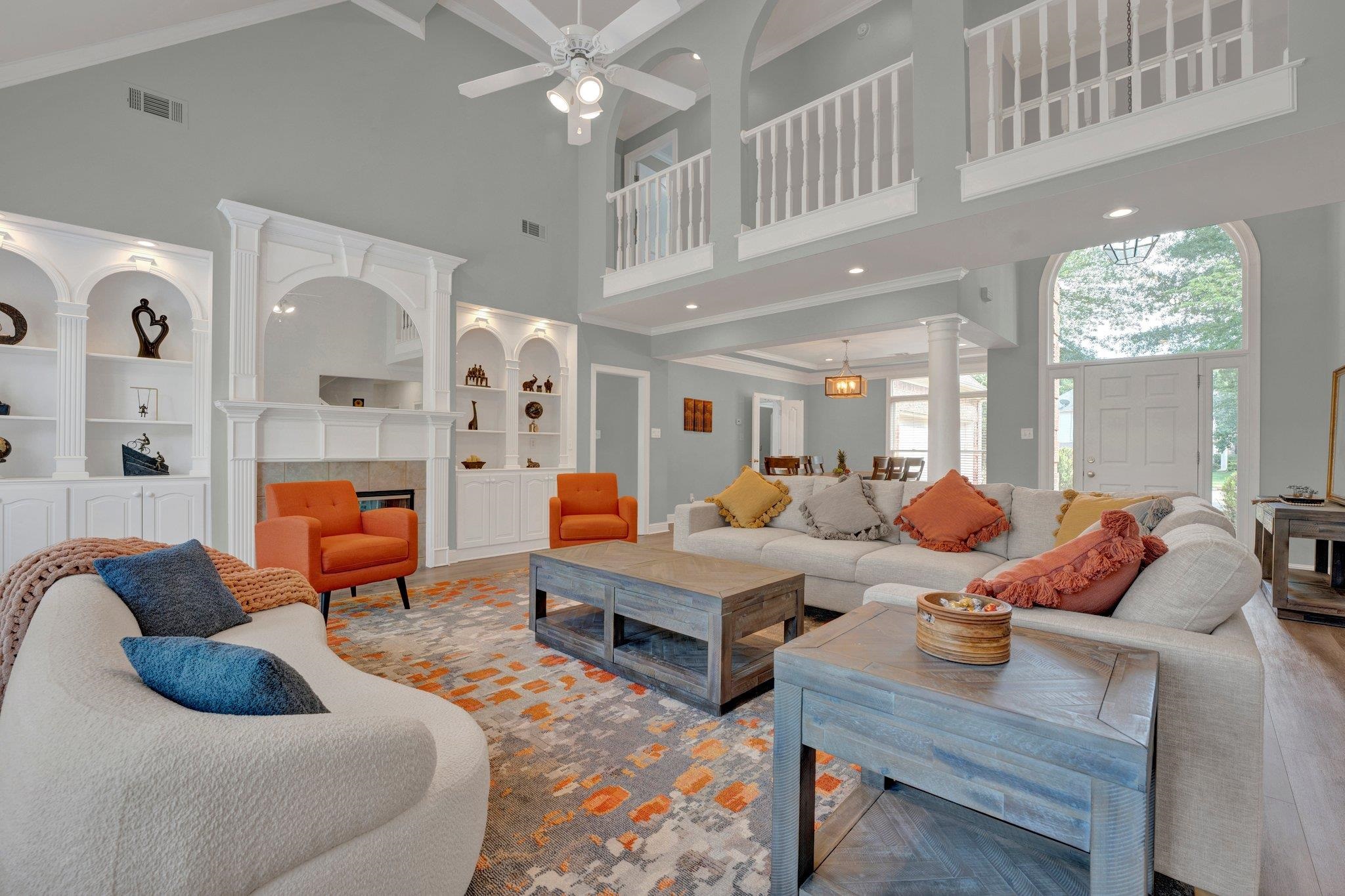 1331 Riding Brook Drive Collierville, TN 38017 - Photo 3 of 39 Living room featuring wood-type flooring, a tiled fireplace, ceiling fan, and a towering ceiling