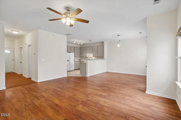 a view of a kitchen with a sink hardwood floor and a refrigerator