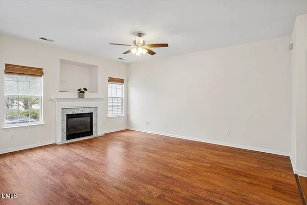 wooden floor fireplace and windows in an empty room