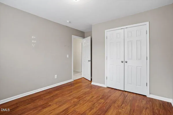 a view of an empty room with wooden floor