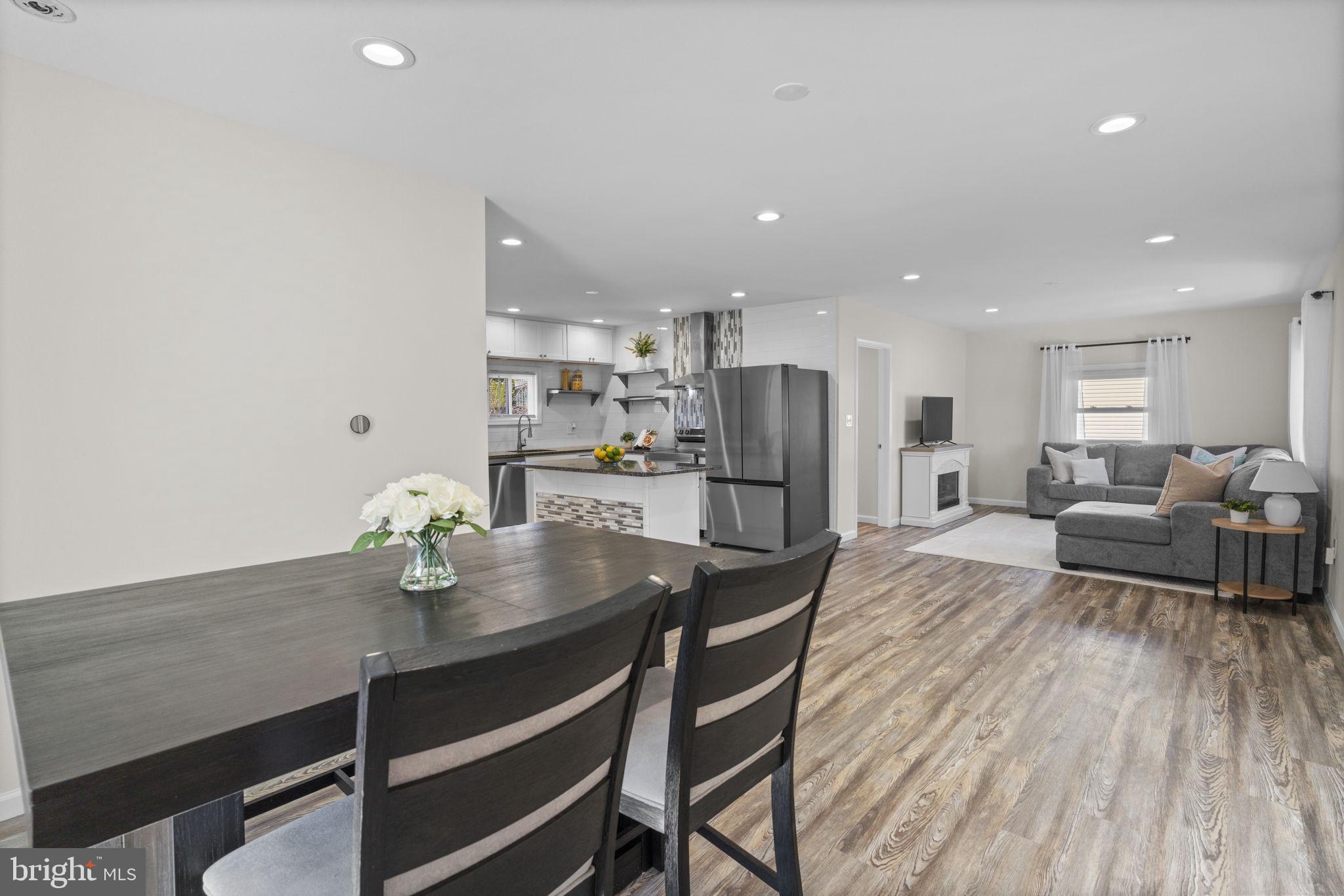 8062 Telegraph Road Severn, MD 21144 - Photo 15 of 45 a living room with stainless steel appliances furniture a dining table and chairs