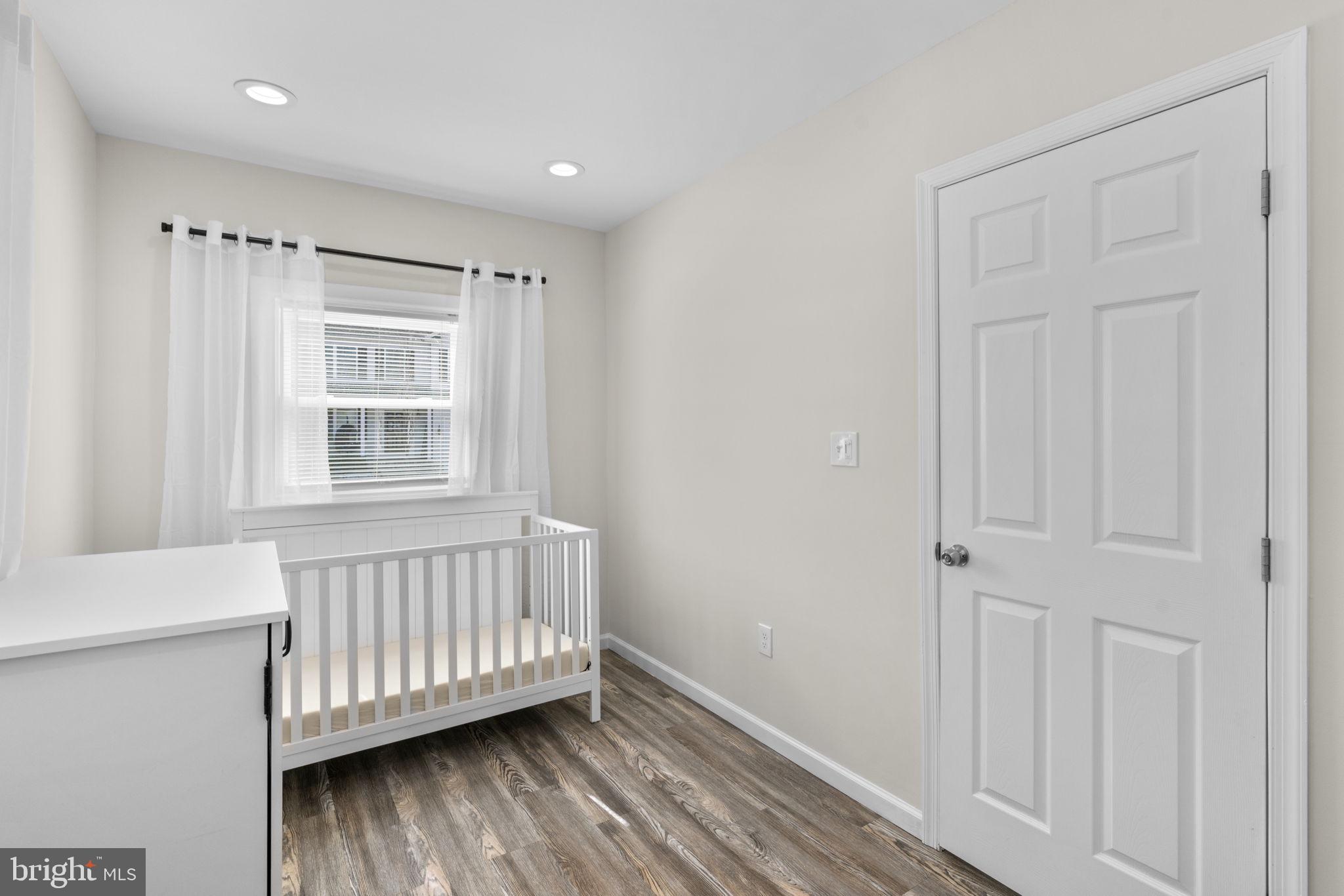 8062 Telegraph Road Severn, MD 21144 - Photo 21 of 45 a view of an empty room with wooden floor and a window