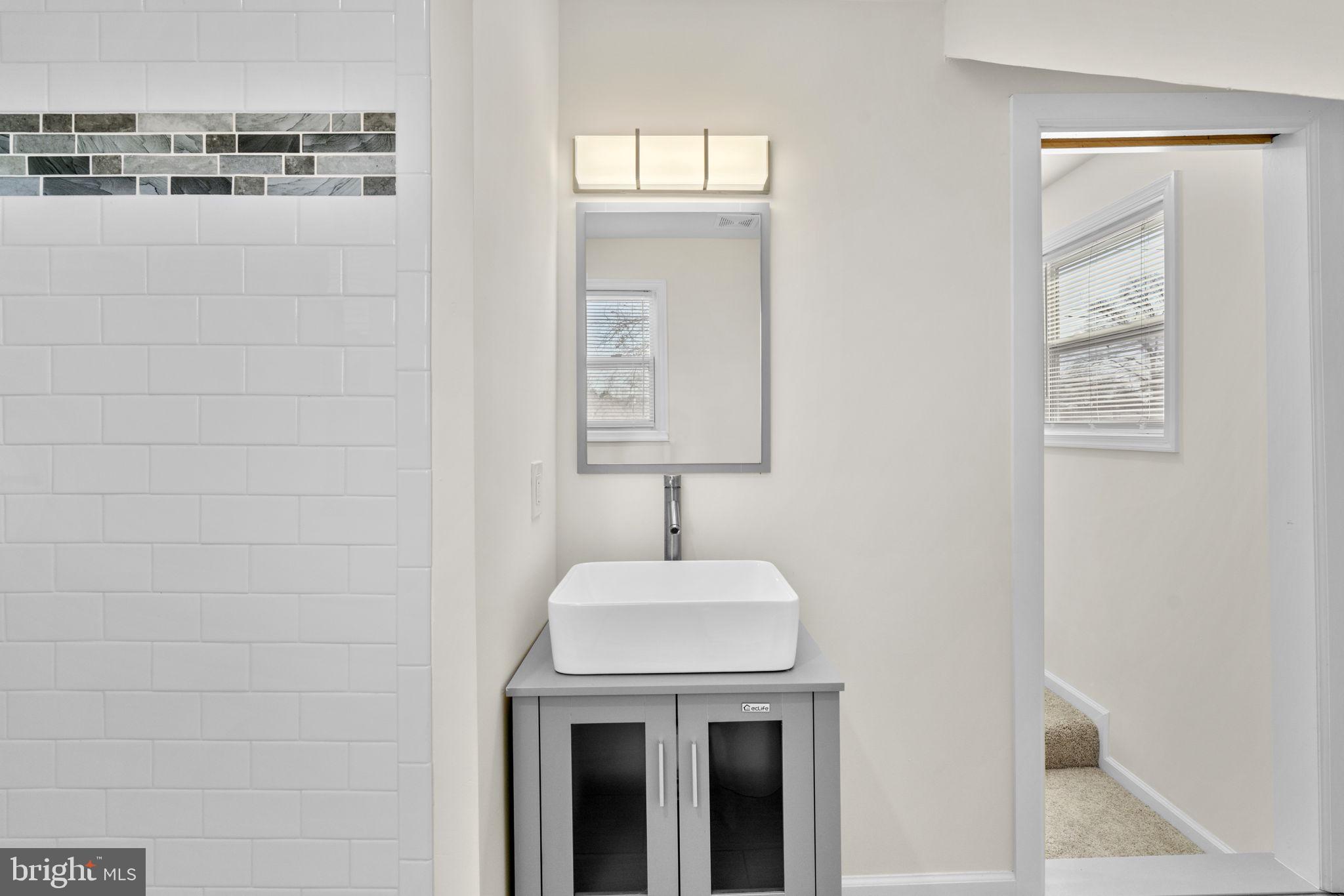 8062 Telegraph Road Severn, MD 21144 - Photo 29 of 45 a bathroom with a sink and a mirror