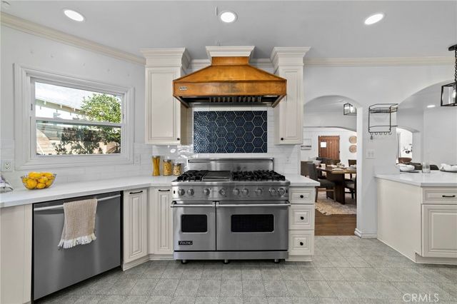 a kitchen with kitchen island granite countertop a sink stove and cabinets