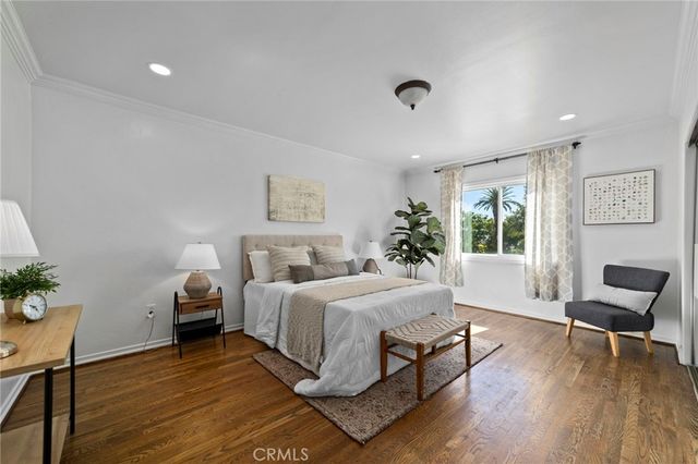 a bedroom with a large bed and a potted plant